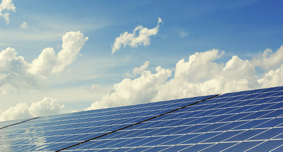 solar panels against a blue sky with white clouds