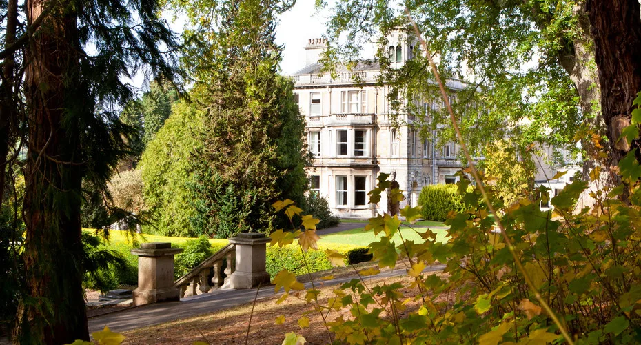 Reed hall framed with green tree leaves.